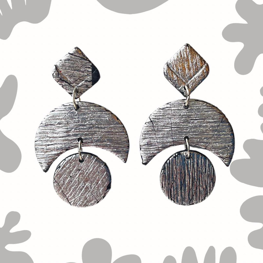 Add some sparkle to your wardrobe with these LUNA - Silver party earrings! Handcrafted and uniquely textured, these earrings are the perfect accessory for any occasion. Give them as a gift to a fellow moon lover (or keep them for yourself - we won't tell). Because let's be honest, who needs an excuse to treat themselves to something shiny? ;)&nbsp;