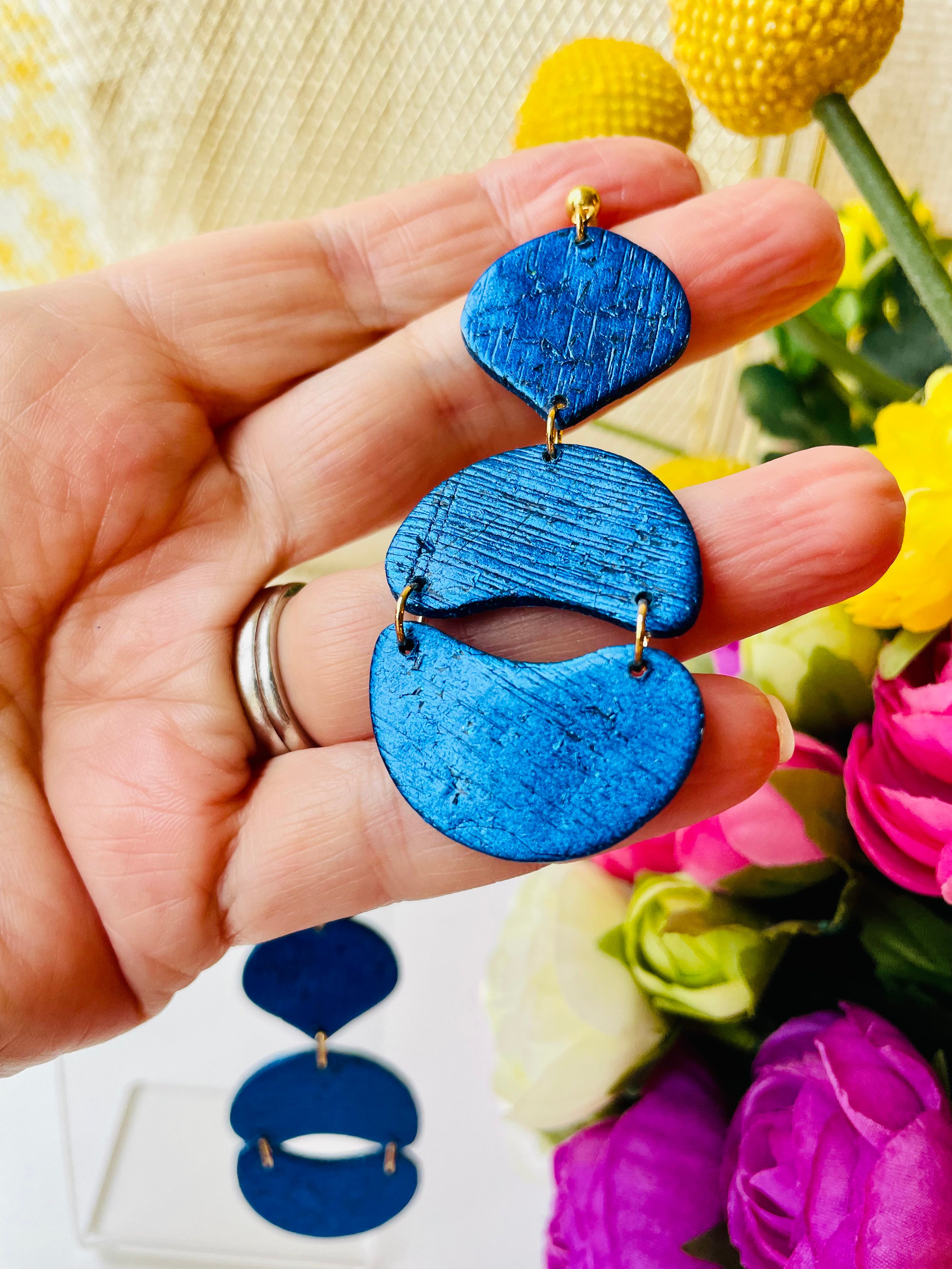 Make a statement with these unique handmade earrings. Exceptional craftsmanship and royal blue color make them the perfect accessory for a special event or just to elevate your everyday look.These unique royal blue earrings are made from polymer clay covered in foil and they have a light stripy texture. The posts are made of stainless steel and come with plastic backs instead of metal butterfly.These stunning earrings measure approximately 3cm width x 7.5cm length and are very light.