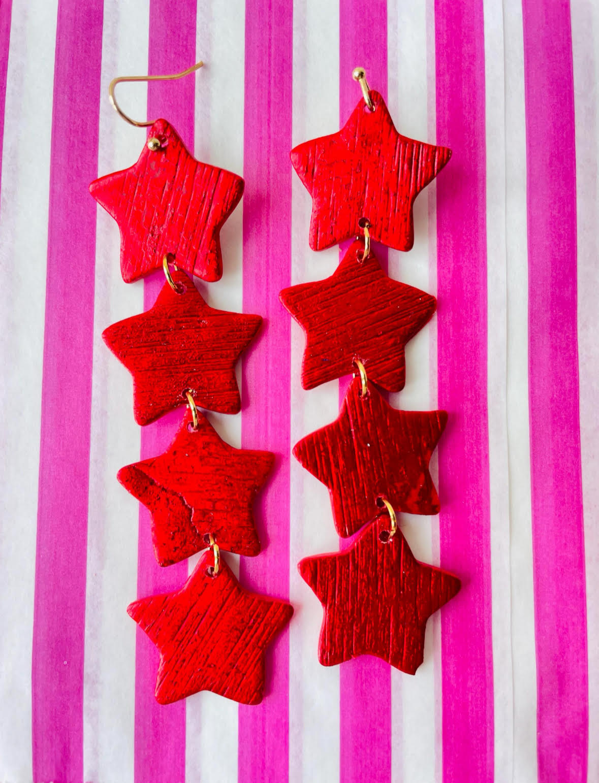 Elegant long red star earrings—perfect for a festive or romantic look. These earrings would make a fun gift for star lovers. Going to a festival this summer? Add some starry charm to your outfit with these light earrings.
These earrings are a true statement in a very bright red. The earrings have been worked with a roller to give them texture. This playful earrings would work as well with jeans or a party outfit. 