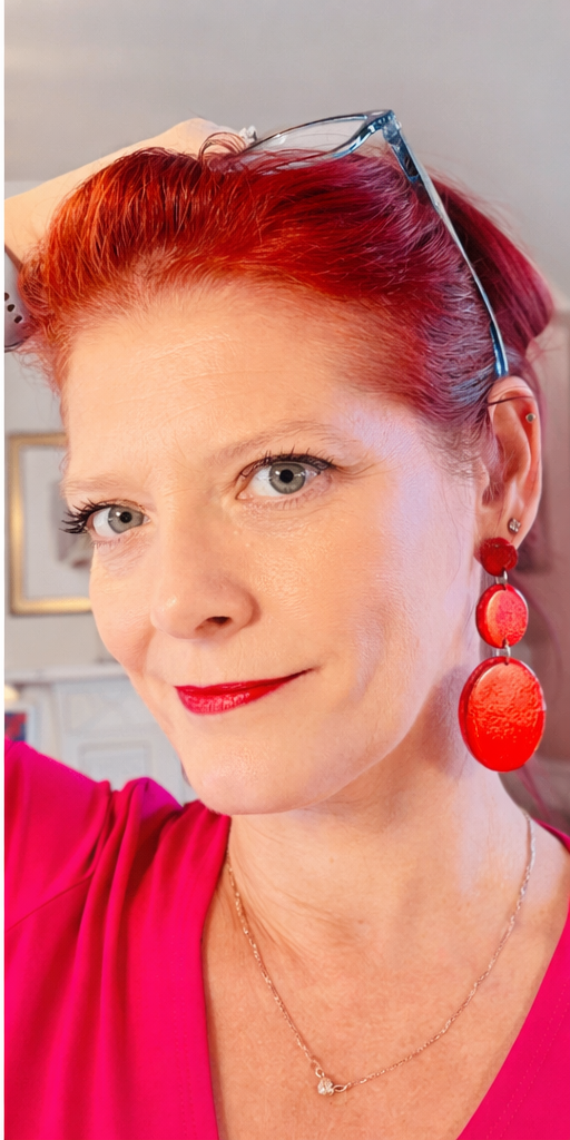 Close-up of model wearing handmade red statement earrings, eye-catching lightweight design with stainless steel posts.