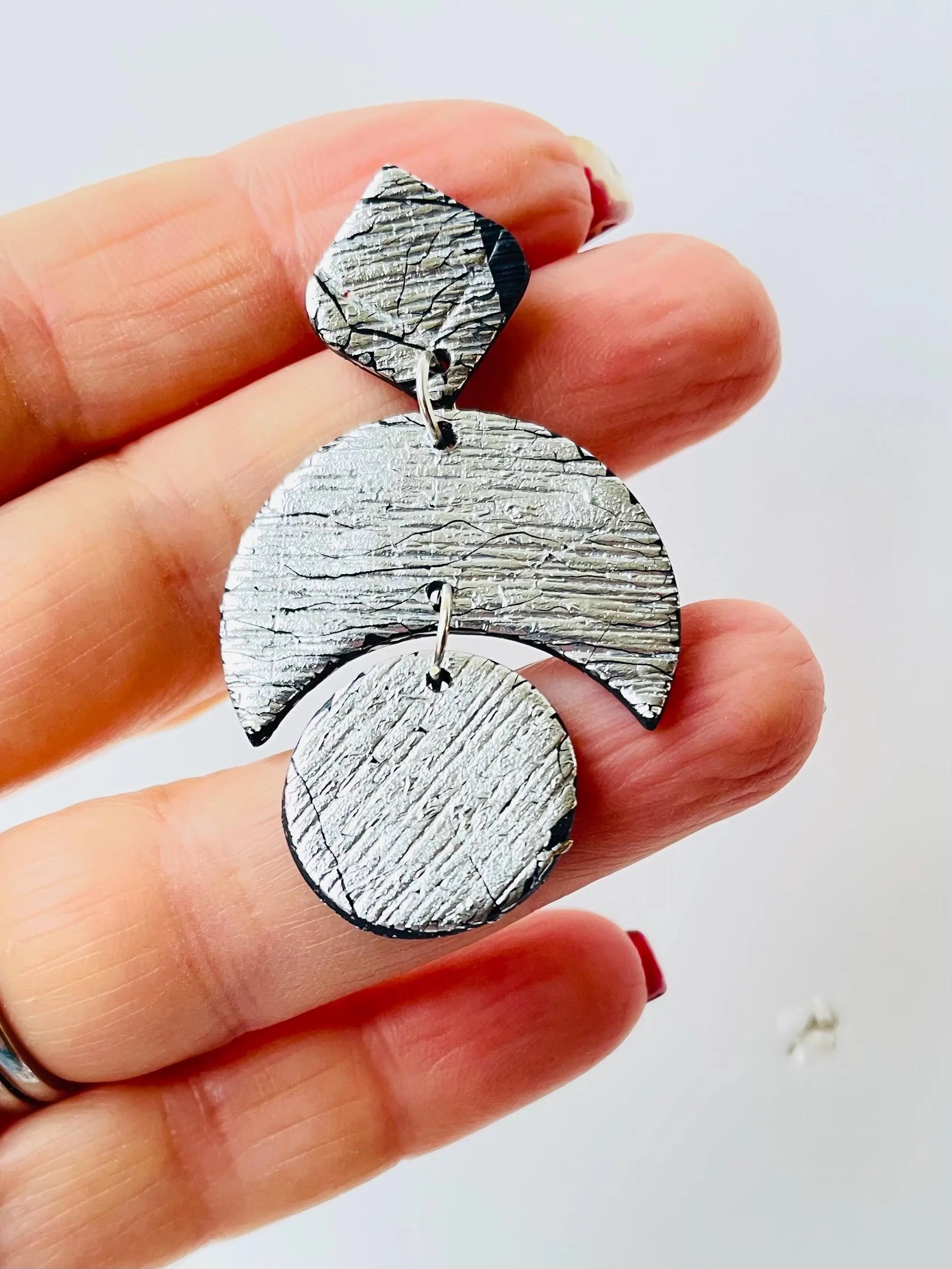 Add some sparkle to your wardrobe with these LUNA - Silver party earrings! Handcrafted and uniquely textured, these earrings are the perfect accessory for any occasion. Give them as a gift to a fellow moon lover (or keep them for yourself - we won't tell). Because let's be honest, who needs an excuse to treat themselves to something shiny? ;)&nbsp;