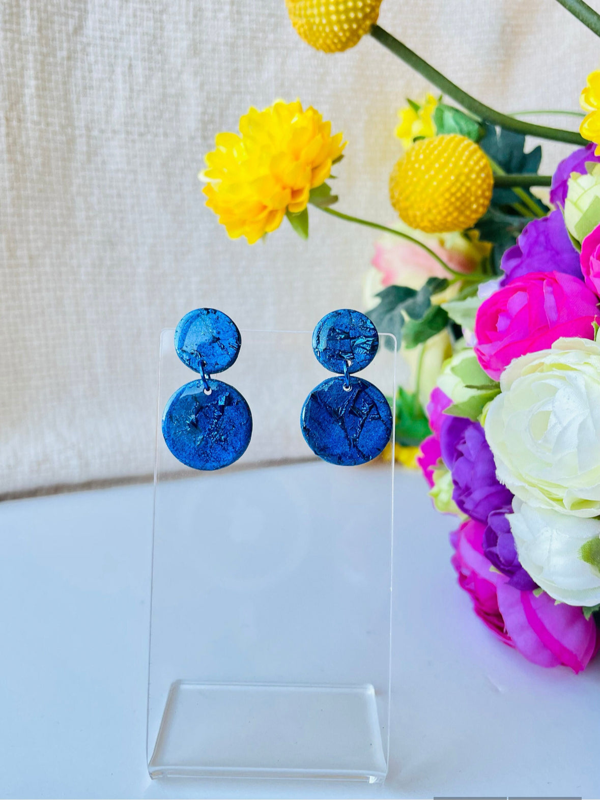 Crafted from vibrant blue polymer clay, these stunning earrings are named after the renowned Venetian island of Murano. Inspired by the island's colorful glass, these small earrings are available in a variety of bold shades, making them the perfect everyday accessory or thoughtful birthday gift.